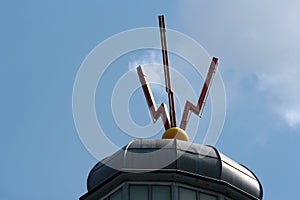 Three sparks, a symbol of electrical discharge on a lightning rod on a rooftop