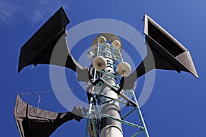 Three speakers hoisted into a light tower photo