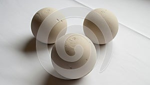 In a triangular formation on a smooth white surface casting soft