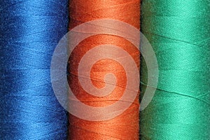 Three spools of polyester threads