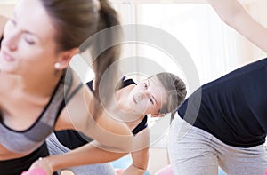 Three Sportive Caucasian Active Women Doing Stretching Exercises with Barbells in Gym