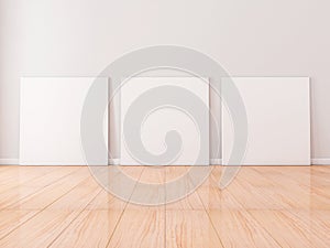 Three Square white Canvases Mockup stand on wooden floor in empty room