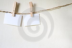 Three squares of blank paper, pegged to a string washing line