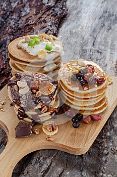 Three stack of pancakes with chocolate, yogurt and caramel syrup.