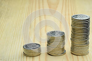Three stacks of iron silver coins on a wooden background