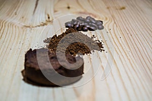 Three stages for preparation of coffee: grain, crushing and the pressed tablet. Wooden surface. Espresso. Work barista.