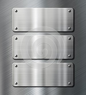Three stainless steel metal plates on brushed