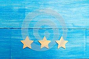 Three stars on a blue background. The concept of rating and evaluation. The rating of the hotel, restaurant, mobile application. Q