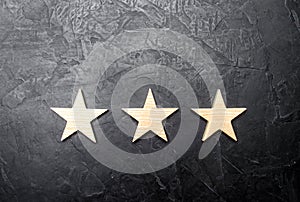 Three stars on a dark background. The concept of rating and evaluation. The rating of the hotel, restaurant, mobile application