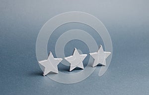 Three stars on a gray background. The concept of rating and evaluation. The rating of the hotel, restaurant, mobile application