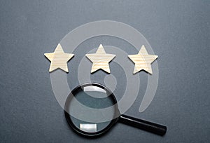 Three stars and a magnifying glass on a dark background. Rating and status of the restaurant or hotel. Prestige. High quality