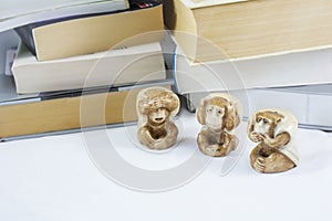 Three statuettes of monkey with many books