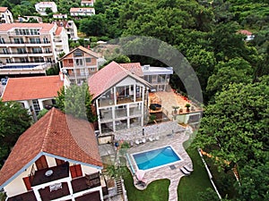 Three-storey villa with a swimming pool and terraces in a green garden. Drone