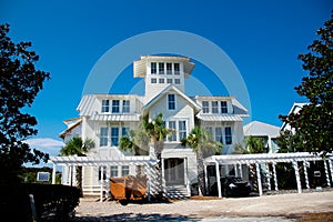 Three-story houses with white pergola and picket fence curb appeal along scenic 30A country road in Santa Rosa, South Walton,