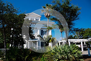 Three-story houses with white pergola and picket fence curb appeal along scenic 30A country road in Santa Rosa, South Walton,