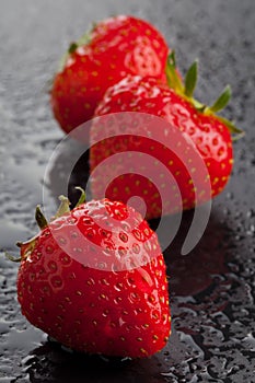 Three strawberries on black