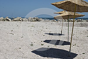 Three Straws umbrellas on the sand sunny beach
