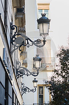 Three street lamps in a street in Madrid