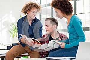 Three students comparing information from two different textbooks