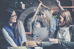 Three students girls at home using digital tablet togeth