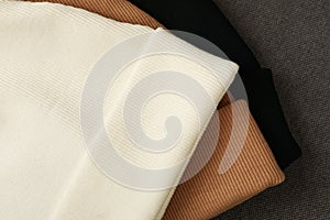 Three stylish beanies on cloth background, close up