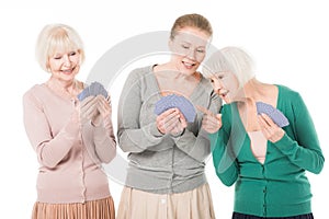 Three stylish smiling women playing cards