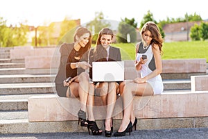 Three Successful businesswomen in the city on a bench discussed photo