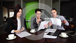 Three successful managers, two guys and girl prepare opinion on validity of insurance payments, use gadgets and looking