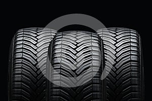 three summer tires on a black background. Drainage grooves and slats photo