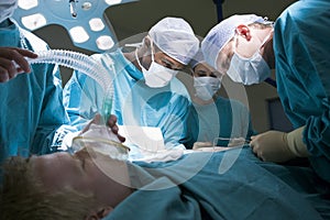 Three Surgeons Operating On A Patient