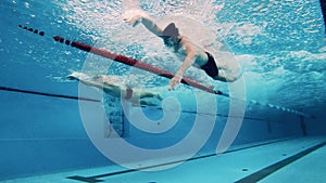 Three swimmers compete with each other. Underwater shot