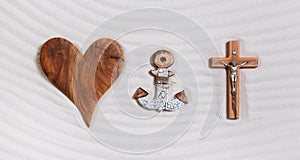 The three symbols of the devine trinity: heart, anchor, cross.