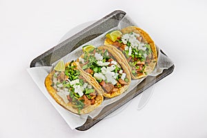 Three tacos on white paper on black tray with lengua meat photo