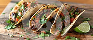 Three Tacos on Wooden Cutting Board