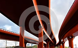 Three tall red road viaducts joining