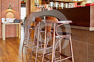 Three tall wooden stools at counter with beverages