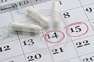 Three tampons on the menstruation calendar photo