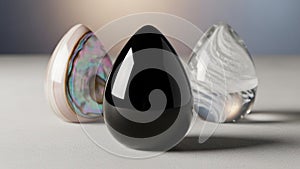 Three teardrop shaped objects are displayed on a smooth surface