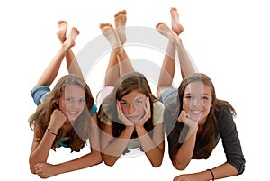 Tri dospievajúci dievčatá ležiaci na poschodie brada v ruke 
