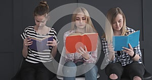 Three teenage girls reading books