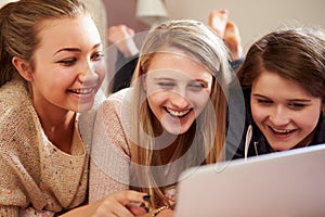 Three Teenage Girls Using Laptop In Bedroom