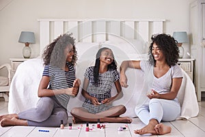 Three Teenage Sisters Giving Each Other Makeover In Bedroom