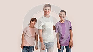 Three teenaged disabled children with Down syndrome and cerebral palsy smiling at camera while posing together isolated