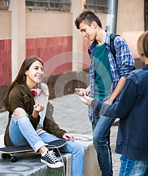 Three teenagers hanging out outdoors