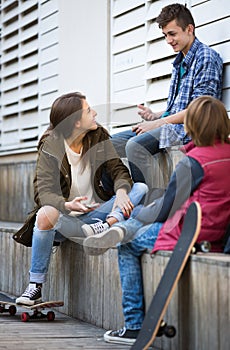 Three teenagers hanging out outdoors