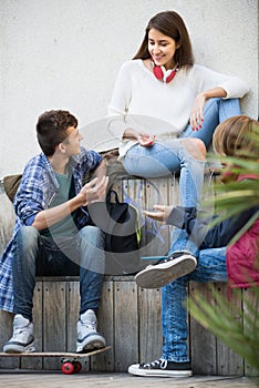 Three teenagers hanging out outdoors