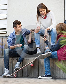 Three teenagers hanging out outdoors