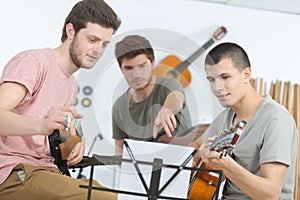 Three teenagers playing music at home