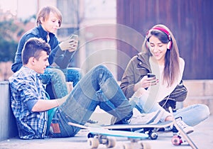 Three teenagers with smartphones