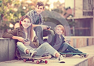 Three teenagers with smartphones in outdoors